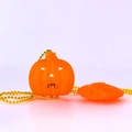 Nahaufnahme der leuchtend orangefarbenen Halloween Kürbis LED-Halskette mit goldener Kette - Mehrfarbiger Kürbis (Halsketten-Stil)