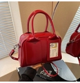 Dettaglio della borsa bowling in vernice rossa con un esclusivo scomparto per carte trasparente - Rosso