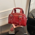 Sac Boston en cuir verni rouge foncé avec boucles argentées et poignées - Bordeaux