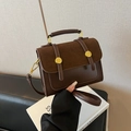 Retro British style crossbody bag in dark brown leather with a top handle and gold hardware - Brown