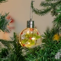 Leuchtende transparente Weihnachtskugel mit Blättern und warmen LEDs am Tannenbaum - Grünes Blatt