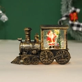 Macro detail of a vintage Christmas train lantern with glowing Santa Claus scene inside - Light Up Gold Train Santa Claus
