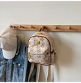 Detail van beige mini-rugzak met berenpatroon hangend aan een houten wandhaak - Rijstwit (Geen Hanger)