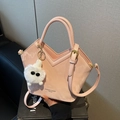 Élégant sac à main rose structuré avec ouverture en V et breloque en peluche blanche pour femmes. - Rose