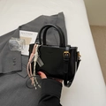 Glossy black mini handbag with stylish charms and adjustable shoulder strap - Black