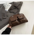 Detail of dark brown quilted pillow bag showing dual front pockets and metal chain strap - Dark Coffee