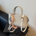 Minimalist light grey leather handbag with double handles and decorative rope charm - Gray