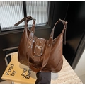 Detail of dark brown patent leather shoulder bag with vintage crackle texture and metal hardware - Coffee