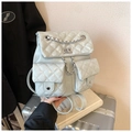 Close-up of quilted mint green backpack with silver chain detail and dual front pockets - Gray