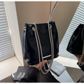 Detail of black glossy bucket bag with silver chain straps and metallic accents - Black