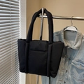 Borsa tote imbottita nera in nylon lucido appesa a una gruccia in metallo - Nero