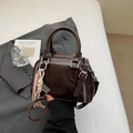 Brown glossy PU pillow bag with white baseball stitching and woven pendant charm - Coffee (With Pendant)