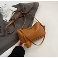 Caramel brown vintage shoulder bag with silver twist lock on gray suit background - Small / Brown