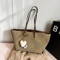 Olive green tote bag with plush heart charm and slim brown straps on soft beige background - Green with Pendant