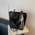 Black star embossed bucket bag featuring a tennis racket charm and woven pendant - With Charm / Black