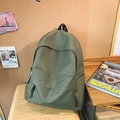 Zaino minimalista in nylon verde oliva con ampia tasca anteriore su sedia in legno - Verde