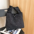 Detail der schwarzen Nylon-Tragetasche mit FaltenGriffen, Tunnelzug und Silbernieten - Schwarz