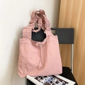 Detailansicht der rosa Nylontasche mit silbernen Nieten und gefaltetem Wolkengurt - Rosa