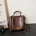 Sac seau marron foncé avec poignée et plaque logo en métal doré au style minimaliste - Marron
