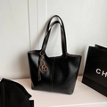 Black leather tote bag with vertical stitching and brown pretzel charm accessory - Black with Pendant