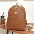 Vintage brown leather backpack with V-shape pocket and gold zippers on a wooden desk - Brown