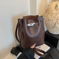 Klassische dunkelbraune Beuteltasche aus Leder mit silbernem Drehverschluss und Narbung - Braun