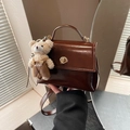 Retro dark brown glossy PU handbag with gold twist lock and a cute plush bear pendant - With Charm / Brown
