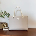 Chic cream textured tote bag with triangular plaque and detachable strap in a cozy setting - Off-white