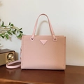 Pink tote bag with woven texture and triangle logo shown on a wooden table - Pink