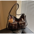 Dettaglio della grande borsa hobo marrone scuro con doppie tasche e cuciture bianche - Con Ciondolo / caffè