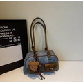 Detail of blue denim tote bag with brown leather pockets and fuzzy bear charm - Denim Blue With Pendant