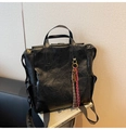 Dettaglio dello zaino vintage in ecopelle nera con ciondolo intrecciato e oro - Nero con ciondolo
