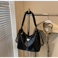 Close-up of black glossy faux leather tote bag with silver triangle logo and adjustable strap - Black without Pendant