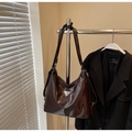 Detail of dark brown glossy leather tote with silver triangular logo and smooth finish - Coffee No Charm
