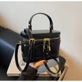 Detailansicht der schwarzen glänzenden Vintage-Box-Tasche mit goldenen Beschlägen - Schwarz