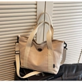 Detalle del bolso tote de lona crema con correa ajustable y etiqueta de la marca - Caqui