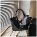 Dettaglio di una borsa tote in pelle PU nera lucida con un ciondolo a forma di orsetto - Nero (Con Ciondolo)