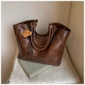 Dettaglio borsa tote marrone scuro con texture in pelle, ciondolo orsetto e nappine - Caffè (Con Ciondolo)