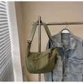 Detail of olive green nylon crescent bag with woven zipper pull on metal stand - Green