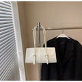 Detalle del bolso baguette de cuero encerado blanco con hebillas metálicas en percha - Blanco Roto