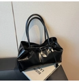 Detalle del bolso tote de charol negro brillante con textura plisada y hebilla metálica fina - Negro