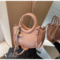 Detail showing pink leather bucket bag with braided rope charms and logo embossing - With Charm / Pink