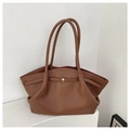 Detailaufnahme der karamellfarbenen Lederstruktur und Goldschnalle der großen Tote Bag - Karamellbraun