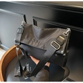 Close-up of black nylon shoulder bag with adjustable wide strap and silver hardware - Black Fabric