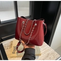 Detalle del bolso de charol burdeos con cadenas de metal plateado y correa de hombro ajustable - Burdeos