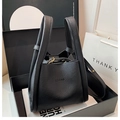 Detalle de bolso tipo cubo en cuero negro grano lichi con cierre metálico elegante - Negro