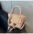 Détail du sac seau rose clair avec logo triangle doré et breloque ruban décorative - Avec Pendentif / Rose