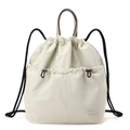 Detail of minimalist beige drawstring backpack showing nylon texture and brand logo - Bone White