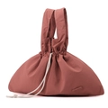 Waterproof rust red nylon handbag with drawstring closure and outer cut leather tag - Berry Red