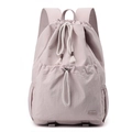 Detail of light pink nylon backpack featuring drawstring closure and rubber brand logo - Peach Pink
